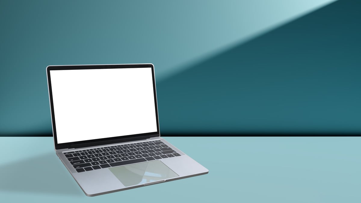 Modern laptop with blank white screen on teal background