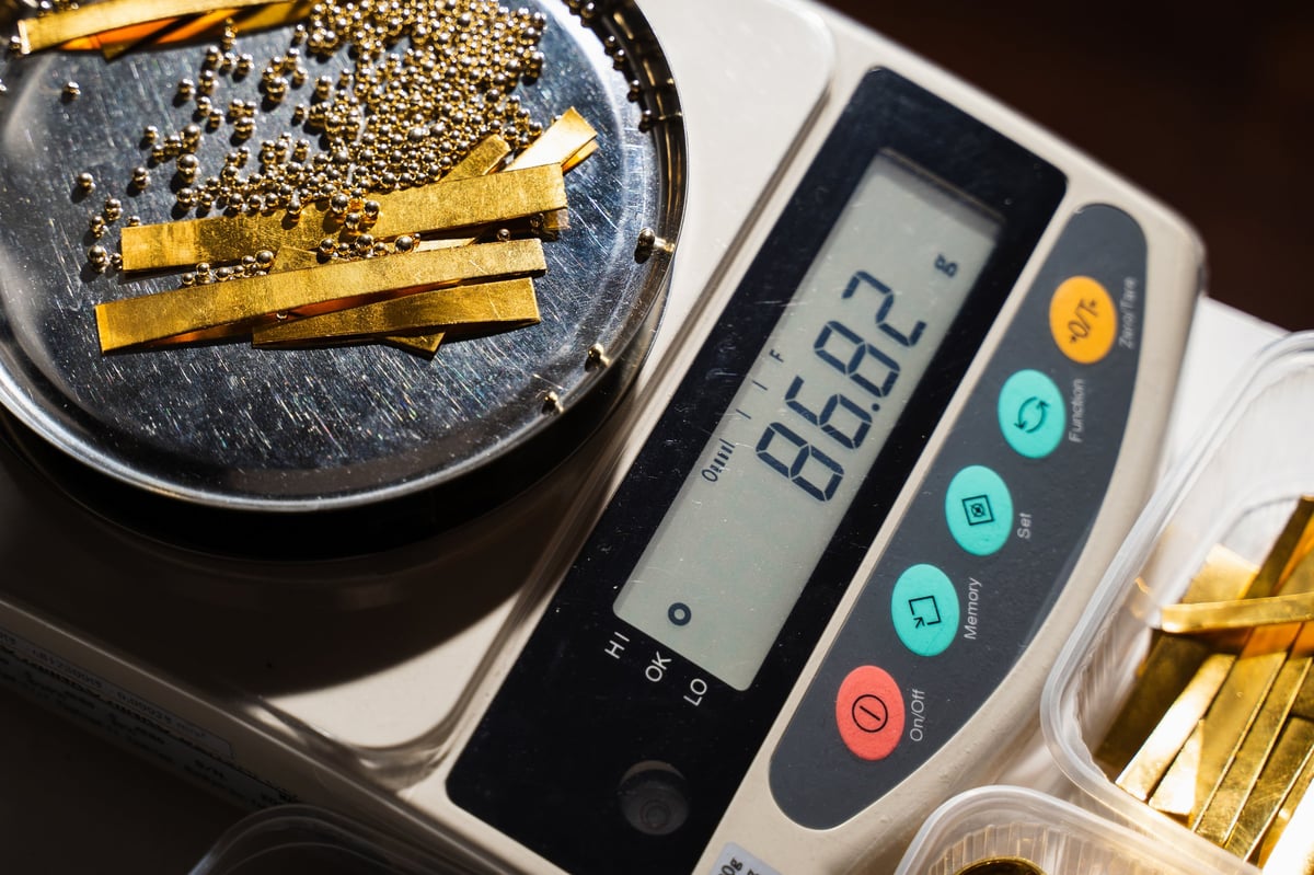 Jeweler carefully weighing gold materials before melting stage